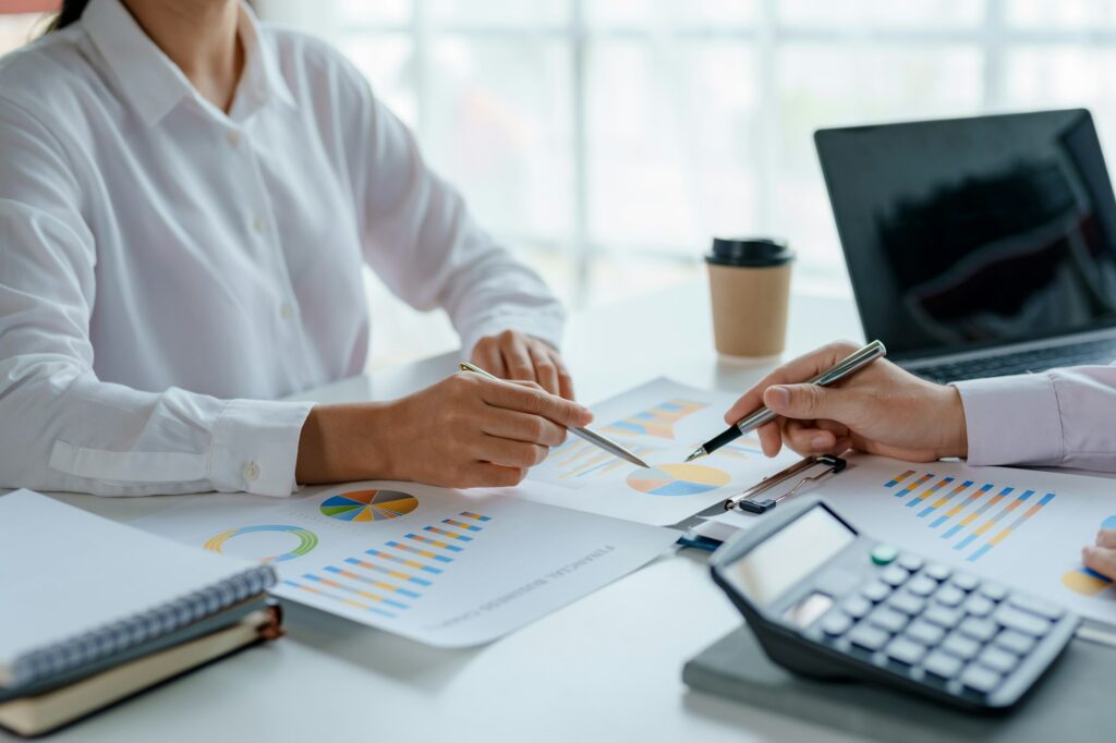 Business people in a meeting and using a calculator to calculate, plan, analyze, create graphs